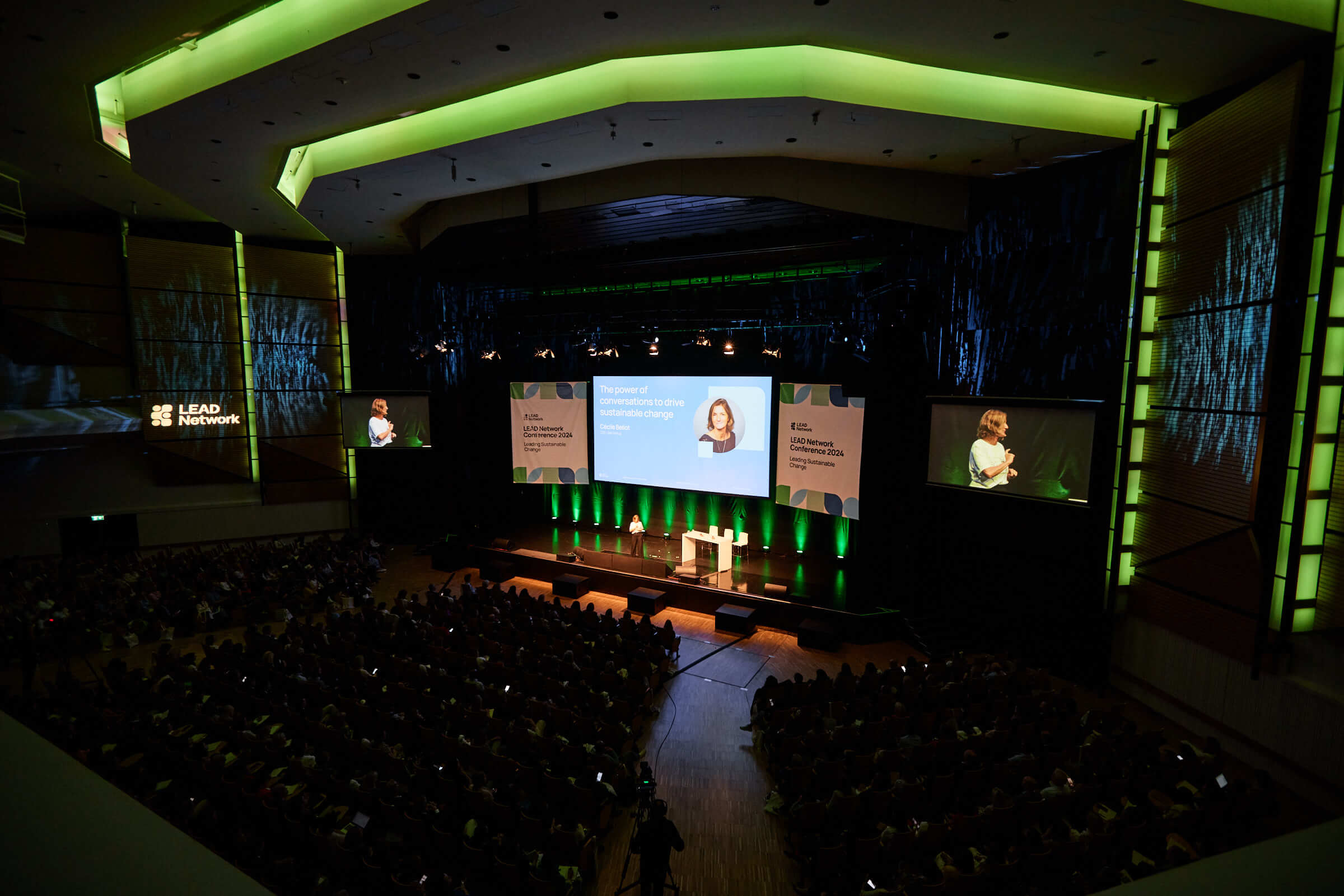 auditorium with keynote speaker and ambient green lighting